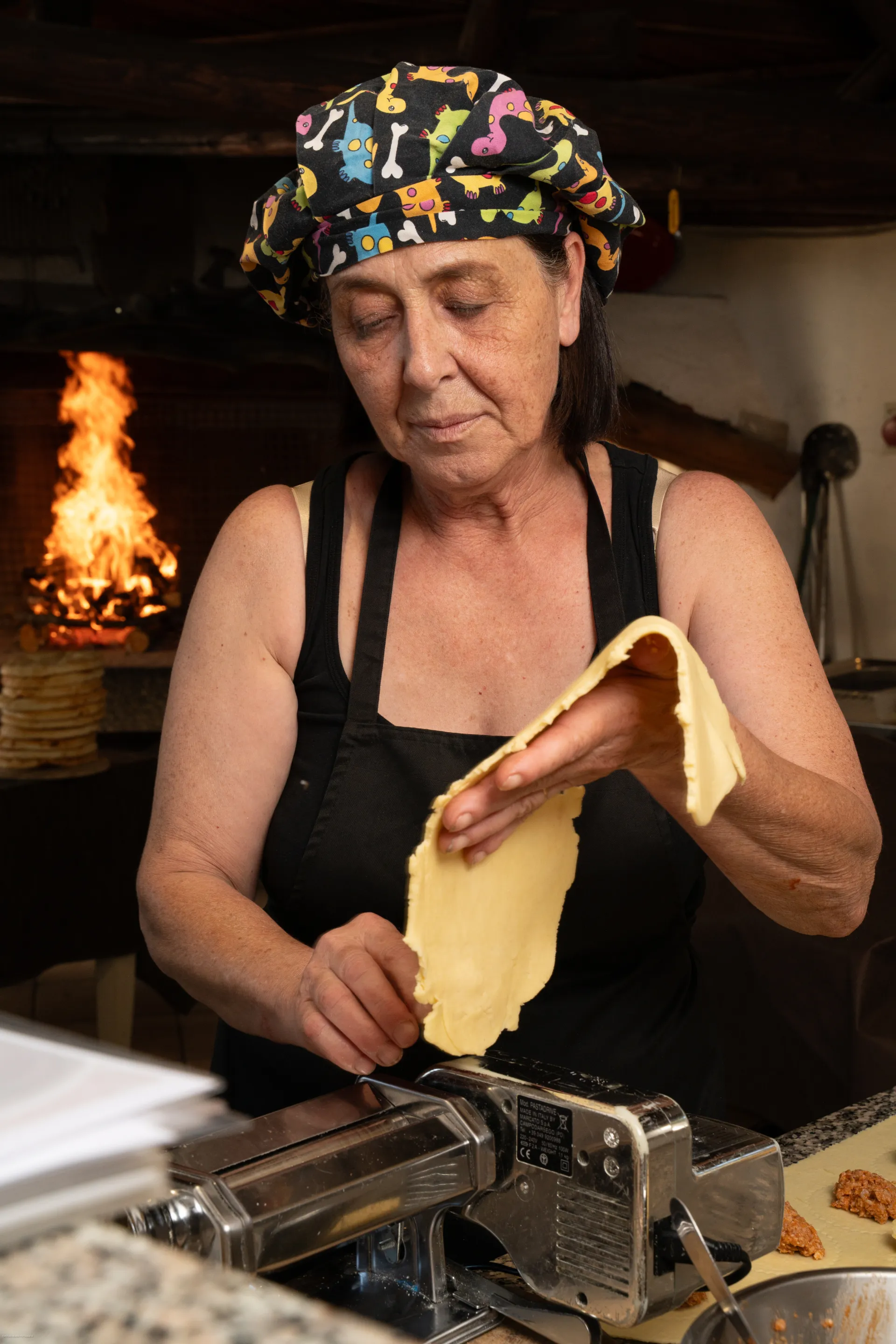 The cook at Locanda Rudalza rolling fresh pasta by hand in front of the hearth